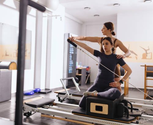 Woman stretching on a pilates bed during her class